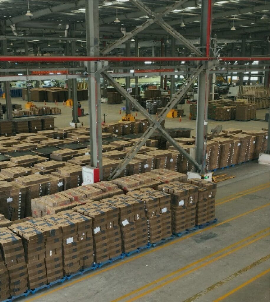 Corrugated cardboard boxes stacked in a large warehouse for packing and shipping.
