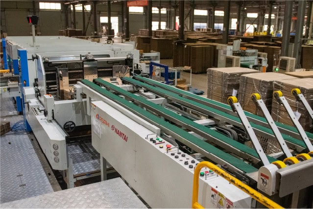 Automated corrugated box manufacturing machinery at SC Pack Box facility.